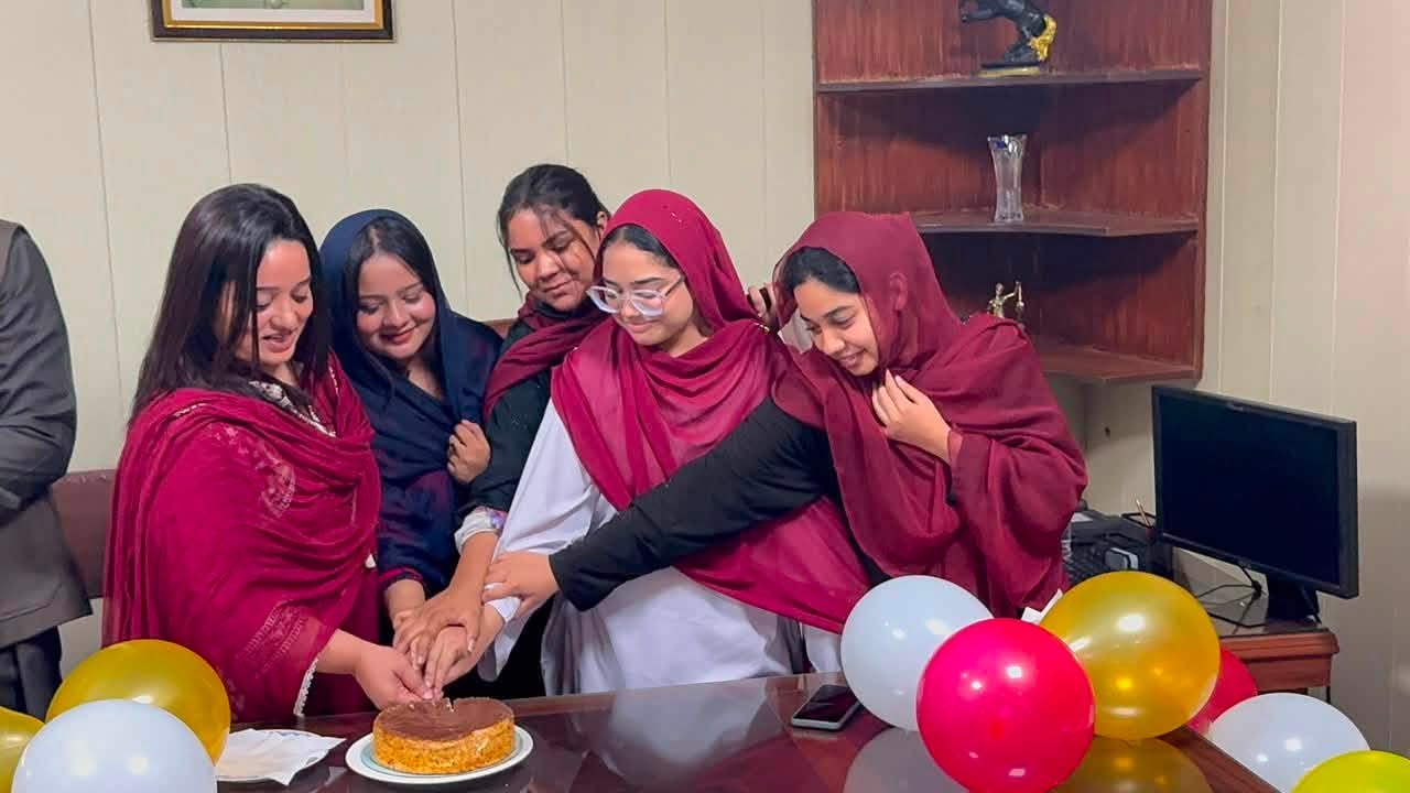 Students celebrating together around the cake